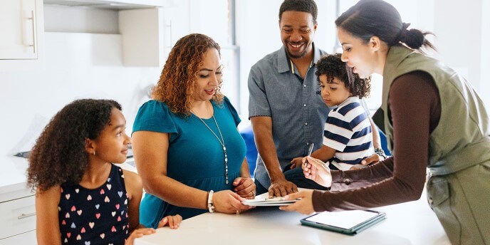 Family in Kitchen signing mortgage