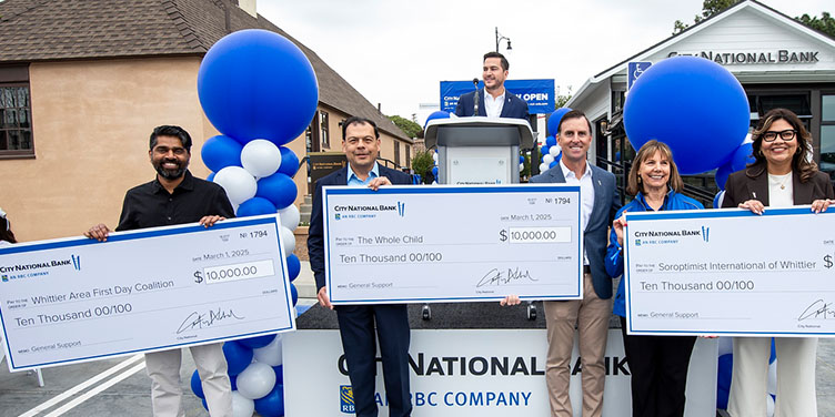 People Holding Giant Charity Donation Checks at Whittier Grand Opening